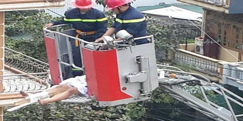 Lực lượng cứu hỏa dùng xe thang giải cứu nam thanh niên nghi ngáo đá. Ảnh: CTV.