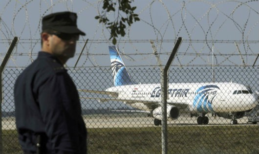 Cảnh sát đứng gác gần phi cơ EgyptAir bị không tặc khống chế ở sân bay thành phố Larnaca, Cyprus. Ảnh: VnExpress/Reuters.