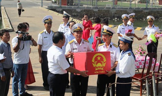 Các cán bộ, chiến sĩ Vùng 2 Hải quân nhận hòm phiếu bầu cử từ ông Mai Ngọc Thuận, Bí thư Thành ủy TP Vũng Tàu, tỉnh Bà Rịa - Vũng Tàu (hàng trước, bên trái), để phục vụ bầu cử sớm trên biển (Ảnh: Người lao động)