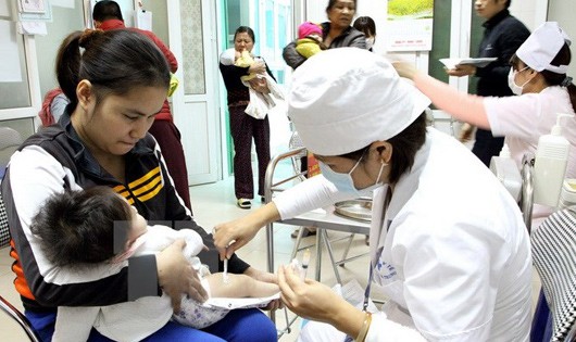 Tiêm vắcxin cho trẻ tại Trạm y tế phường Trương Định, quận Hai Bà Trưng, Hà Nội. (Ảnh: TTX)