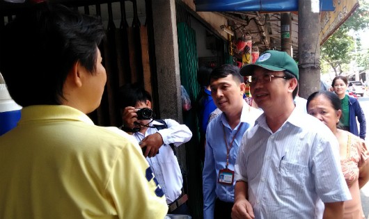 Ông Trần Thế Thuận, Chủ tịch UBND quận 1, TP HCM (đội mũ xanh, bên phải), trực tiếp đến động viên các tiểu thương trả lại vỉa hè bị lấn chiếm.