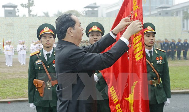 Chủ tịch nước Trần Đại Quang gắn Huân chương Quân công hạng Nhất lên lá cờ truyền thống của Bộ Tư lệnh Binh chủng Đặc công.Ảnh: TTXVN