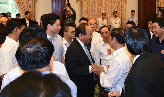 Thủ tướng trò chuyện với các đại biểu bên thềm Hội nghị doanh nghiệp Việt Nam năm 2016. Ảnh: VGP