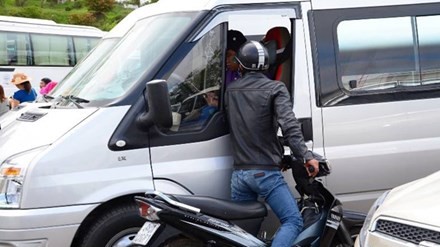 “Cò”đi xe máy “tiếp cận” du khách trên ô tô trước Vườn hoa Đà Lạt. Ảnh: Báo Tiền phong.