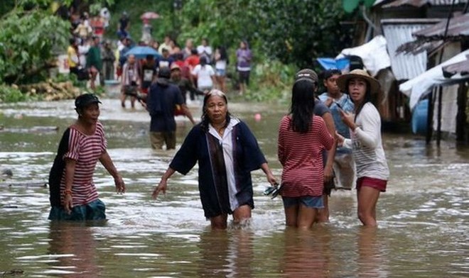 Người dân lội qua một con đường bị ngập lụt ở một ngôi làng ở Borongan, phía đông Samar, miền trung Philippines. (Nguồn: AFP)