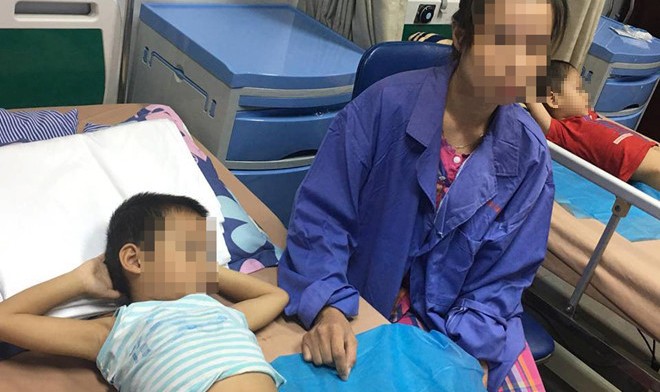 Chị Nguyễn Thị Hương (Khoái Châu, Hưng Yên) đang chăm sóc con trai mắc bệnh sùi mào gà tại Bệnh viện Da liễu Trung ương hôm 17/7. Ảnh: Hà Quyên.