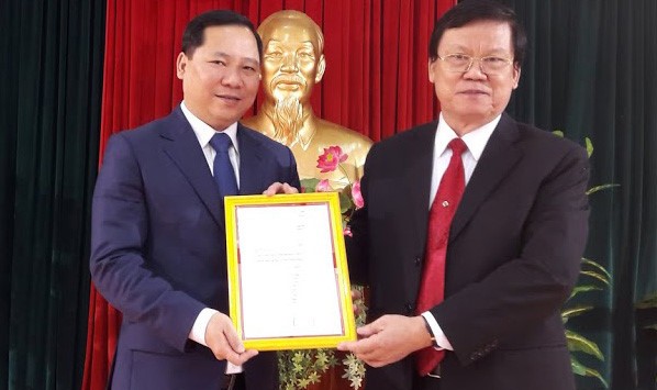 Ông Nguyễn Phi Long (trái) nhận quyết định phân công nhiệm vụ mới. Ảnh: Báo Thanh Niên.