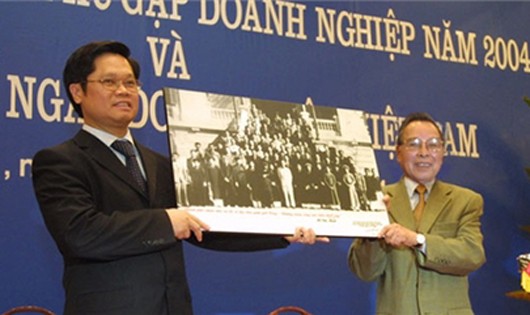 Thủ tướng Phan Văn Khải tặng Chủ tịch VCCI Vũ Tiến Lộc bức tranh Bác Hồ với giới công thương Hà Nội nhân dịp công bố "Ngày Doanh nhân Việt Nam" năm 2004. Ảnh: Vneconomy