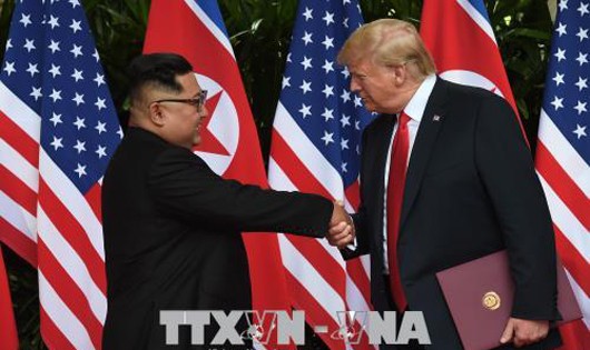 Tổng thống Mỹ Donald Trump (phải) và nhà lãnh đạo Triều Tiên Kim Jong-un (trái) trong cuộc gặp thượng đỉnh tại Singapore ngày 12/6. Ảnh: YONHAP/ TTXVN