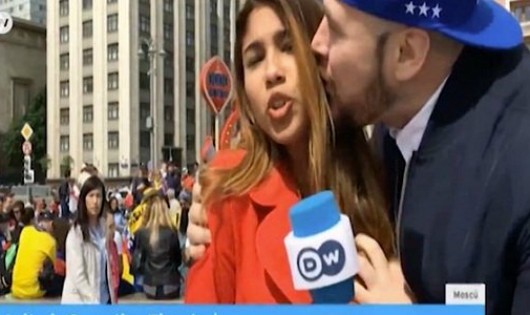 Nữ phóng viên bị một cổ động viên ôm hôn trên sóng truyền hình.