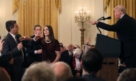 Một nhân viên Nhà Trắng tìm cách tước micro từ tay phóng viên Acosta khi ông đang hỏi Tổng thống Trump. Ảnh: Reuters
