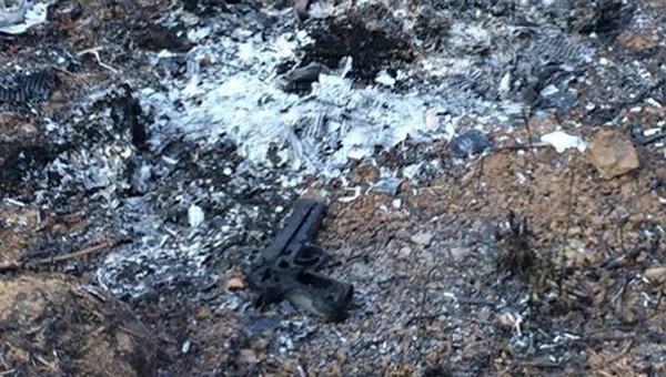 Khẩu súng bị đốt cháy tại khu vực hoang vắng. Ảnh: Công an tỉnh Đồng Nai.