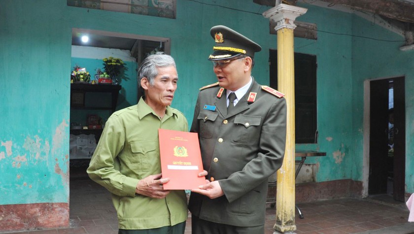 Thiếu tướng Tô Ân Xô - Giám đốc Công an tỉnh Bắc Giang trao quyết định thăng cấp bậc hàm lên Trung tá cho đại diện gia đình anh Nguyễn Quang Luận. Ảnh: Cục CSGT.