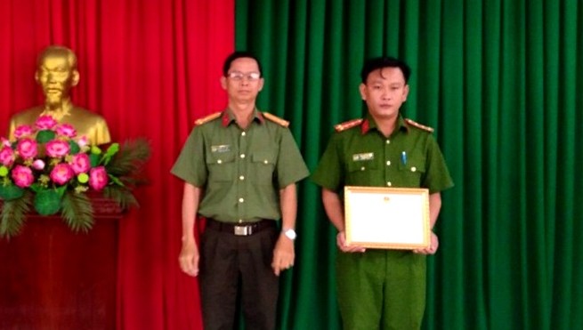 Đại úy Cao Duy Khánh (bên phải) nhận giấy khen của Giám đốc Công an tỉnh Long An. Ảnh: Công an tỉnh Long An.