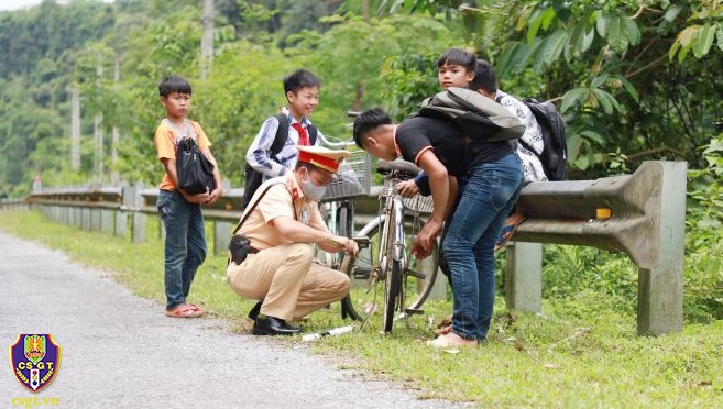 'Đốn tim' hình ảnh chú cảnh sát ngồi bên đường sửa xe cho học sinh 