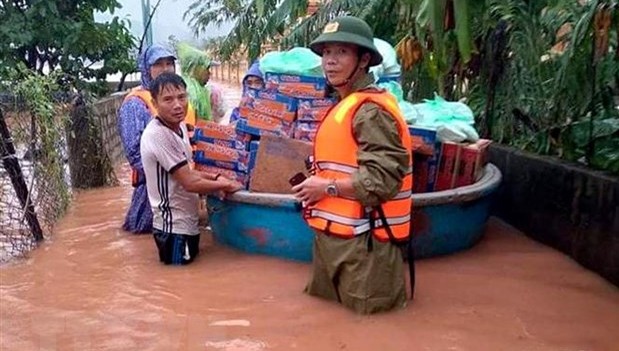 Ông Phan Thanh Miên (phải) dầm mưa, lội nước lũ cùng các đoàn cứu trợ đi cấp phát nhu yếu phẩm tiếp tế cho bà con trong đợt mưa lũ lịch sử vừa qua. 