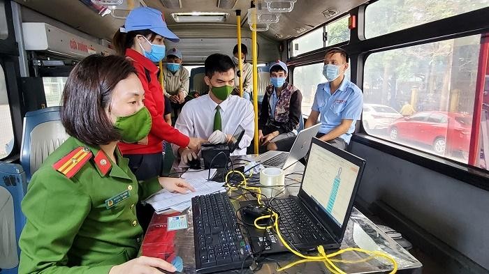 Công an quận Long Biên tiến hành thủ tục cấp căn cước công dân gắn chíp cho người dân trên xe buýt. Ảnh: Cổng giao tiếp điện tử UBND TP Hà Nội