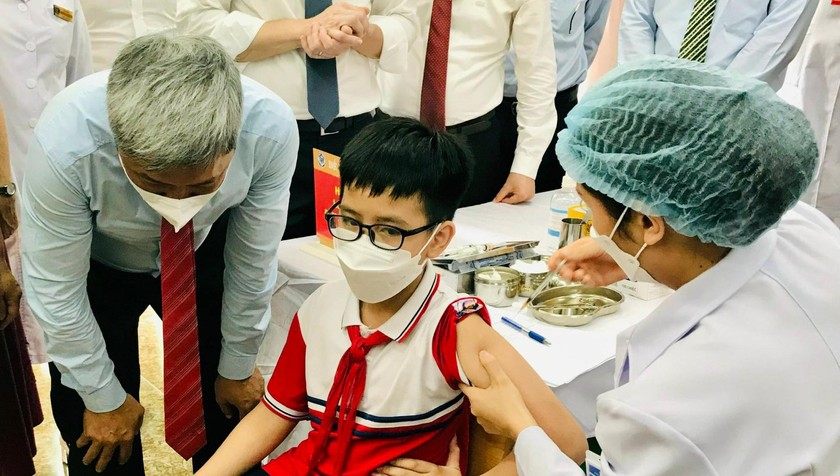 Thứ trưởng Nguyễn Trường Sơn động viên các cháu tiêm những mũi vaccine đầu tiên ở Quảng Ninh. Ảnh. Báo Sức khỏe & Đời sống