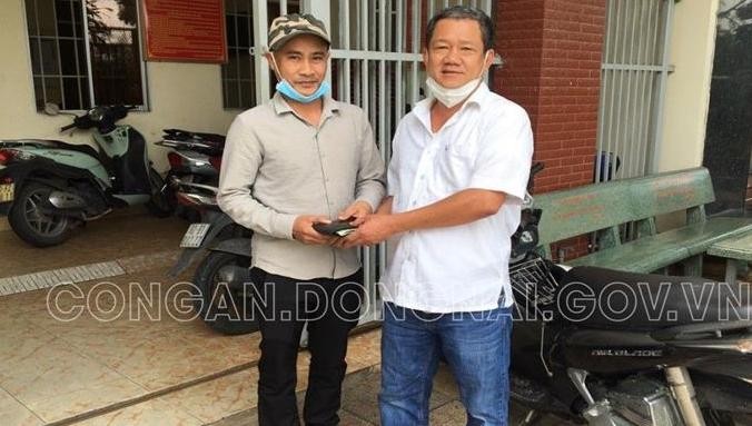Trung tá Nguyễn Văn Sơn (bên phải) trao trả tài sản cho anh Nguyễn Ngọc Nghĩa. Ảnh: Công an tỉnh Đồng Nai.