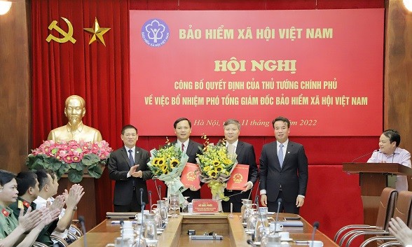 Thừa ủy quyền của Thủ tướng Chính phủ, Bộ trưởng Bộ Tài chính, Chủ tịch Hội đồng quản lý BHXH Hồ Đức Phớc trao quyết định và tặng hoa chúc mừng hai tân Phó Tổng Giám đốc BHXH Việt Nam.