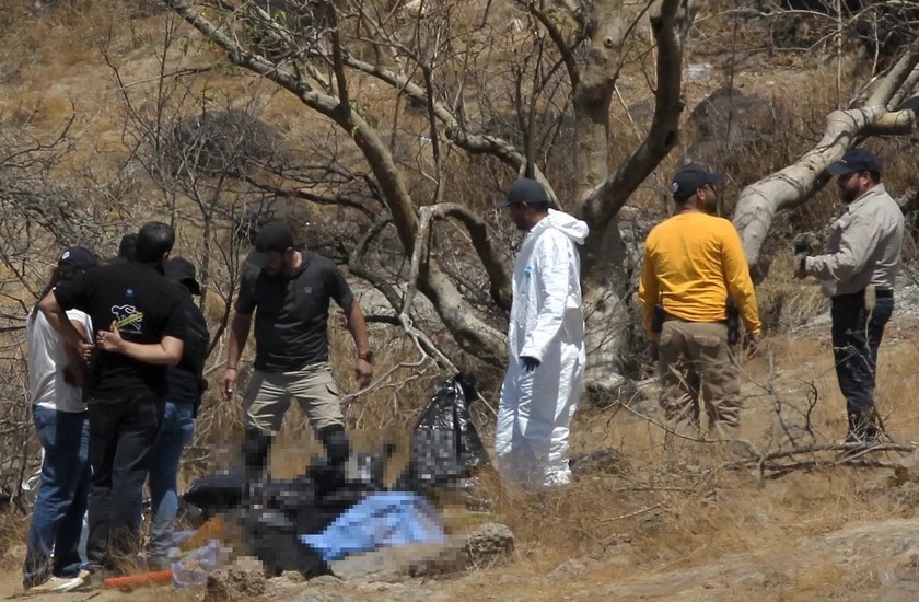 Chuyên gia pháp y tại hiện trường phát hiện các túi đựng bộ phận thi thể người ở ngoại ô thành phố Guadalajara, Mexico ngày 31/5. Ảnh: AFP.
