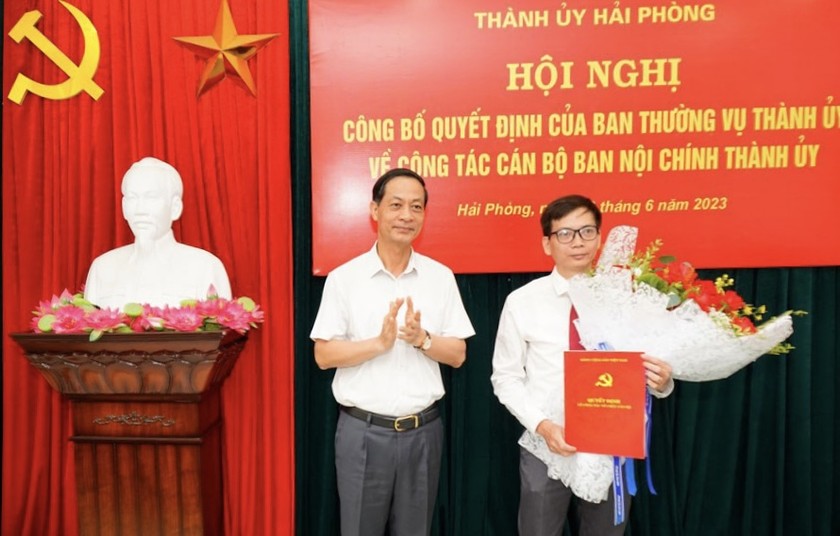 Phó Bí thư Thường trực Thành ủy Hải Phòng trao Quyết định và tặng hoa cho ông Trần Thanh Minh.