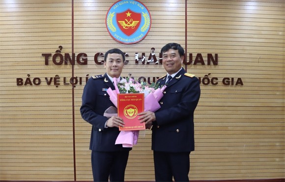 Phó Tổng cục trưởng Nguyễn Văn Thọ (phải) trao quyết định và tặng hoa chúc mừng tân Phó Cục trưởng Trần Xuân Lộc. Ảnh: Báo Hải quan.
