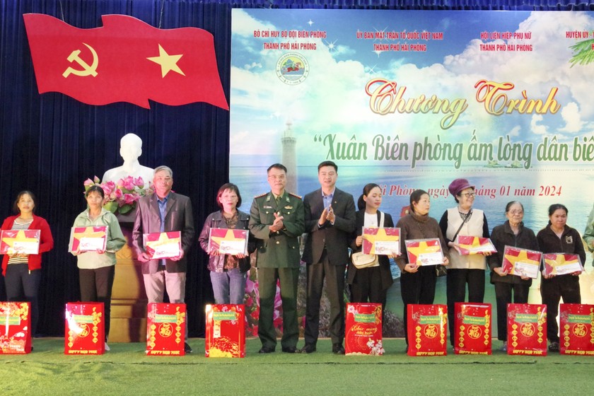 Đại tá Phạm Hồng Phong, Chính ủy Bộ đội Biên phòng TP và ông Bùi Tuấn Mạnh, Chủ tịch UBND huyện Cát Hải trao quà cho các hộ gia đình. Ảnh: Nguyễn Khánh