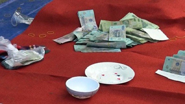 Dụng cụ đánh bạc và số tiền cơ quan công an thu được tại chiếu bạc.