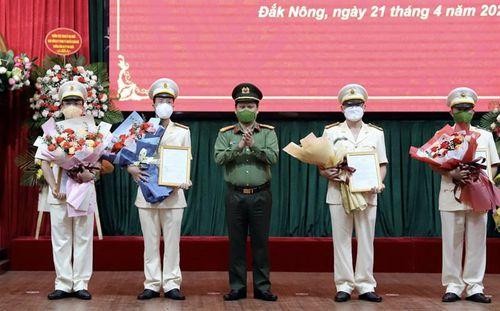 Đại tá Bùi Quang Thanh - Giám đốc Công an tỉnh trao quyết định và tặng hoa cho các cán bộ phó trưởng phòng. Ảnh: CA