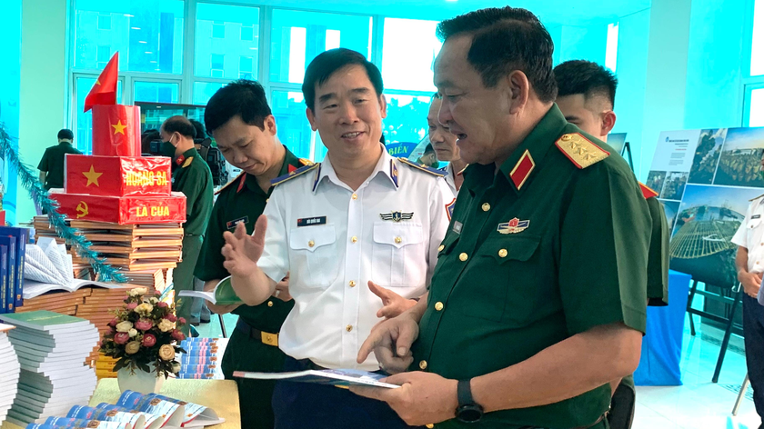 Thiếu tướng Bùi Quốc Oai giới thiệu sách và tài liệu với Thượng tướng Võ Minh Lương tại phòng trưng bày.