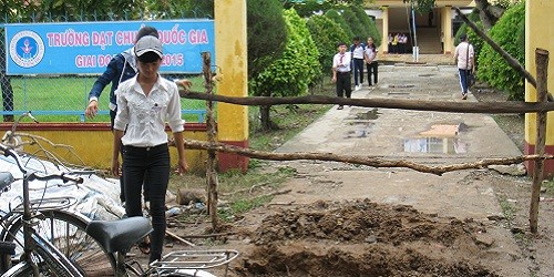Các em học sinh  Trường THCS Nguyễn Du phải chen qua hàng rào để vào trường học.