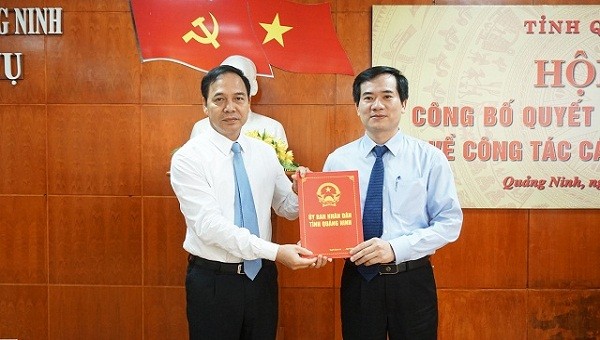 Phó Chủ tịch Thường trực UBND tỉnh Đặng Huy Hậu (bên trái) trao quyết định cho ông Vũ Quyết Tiến