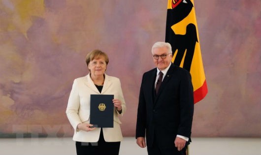 Bà Angela Merkel (trái) nhận quyết định bổ nhiệm từ Tổng thống Frank-Walter Steinmeier sau khi tái đắc cử Thủ tướng Đức