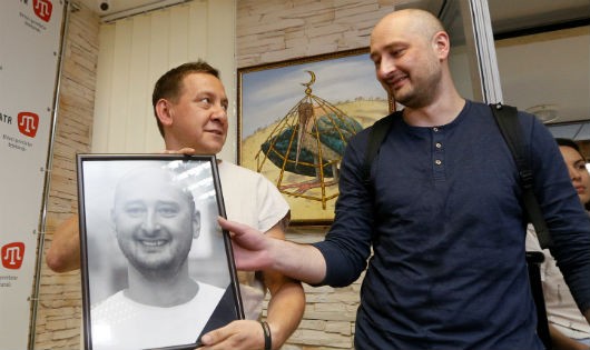 Babchenko cầm bức ảnh chân dung của mình mà các đồng nghiệp đặt tại góc tưởng niệm ông ở văn phòng kênh ATR TV, Kiev hôm 31/5