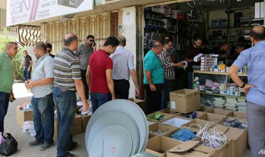 Người dân Iraq xếp hàng đăng ký truyền hình vệ tinh hôm 18/6, song phần lớn người dân không thể chi trả khoản tiền này.