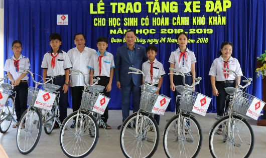 Ông Trần Quốc Trung, Bí thư Thành ủy Cần Thơ (thứ 3 trừ trái sang) và ông Nguyễn Việt Thung, Tổng Giám đốc Cty CP Toàn cầu TMS (áo xanh) trao tặng xe đạp cho học sinh có hoàn cảnh khó khăn