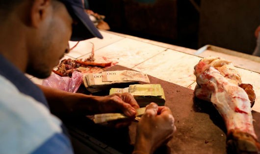 Cả xấp tiền bolivar chỉ mua được một khúc xương. Ảnh chụp tại một hàng thịt ở Maracaibo, Venezuela ngày 26/07/2018