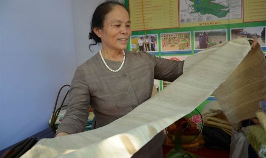 Nghệ nhân Phan Thị Thuận bên một tấm khăn được dệt từ tơ sen