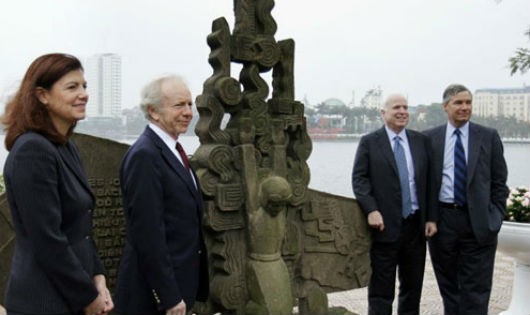 McCain (thứ hai từ phải sang) chụp ảnh tại tượng đài phi công Mỹ bị bắn rơi ở hồ Trúc Bạch vào năm 2012 