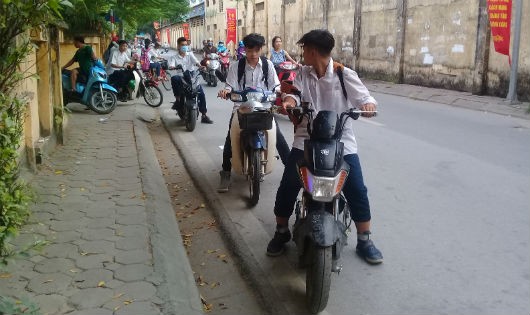 Nhiều học sinh thờ ơ với việc đội mũ bảo hiểm khi tham gia giao thông bằng xe đạp điện, xe gắn máy.