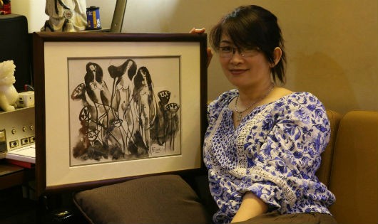 Họa sỹ Phương Bình bên tác phẩm của mình.