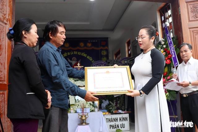 Trưởng Ban thi đua khen thưởng tỉnh Đồng Nai Vy Vũ Hồng Thảo trao bằng khen của chủ tịch UBND tỉnh cho thân nhân anh Tùng