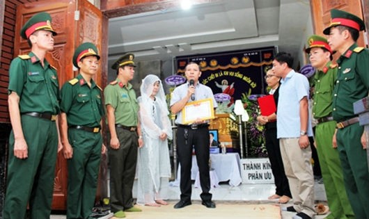 Phó Chủ tịch UBND huyện Trảng Bom Lê Ngọc Tiên truy tặng Giấy khen cho đại diện gia đình anh Tùng.