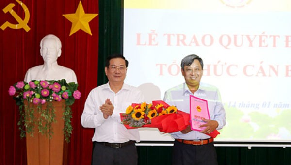 Phó Chủ tịch UBND tỉnh Đồng Tháp Nguyễn Thanh Hùng (trái) trao Quyết định và hoa chúc mừng ông Nguyễn Thanh Nhàn