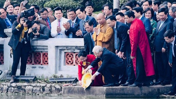 Tổng Bí thư, Chủ tịch nước Nguyễn Phú Trọng và Phu nhân cùng đại diện kiều bào thực hiện nghi thức thả cá chép tại Hồ Gươm.  