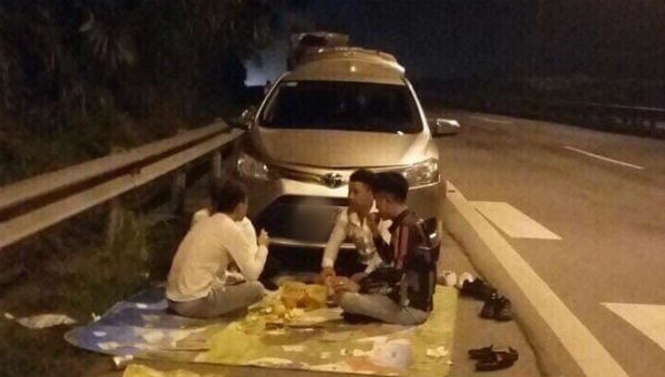 Nhóm thanh niên trải bạt ăn uống trên đường cao tốc