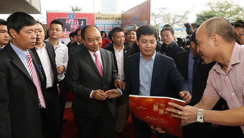 Phó Tổng biên tập Báo Pháp luật Việt Nam Trần Đức Vinh giới thiệu các ấn phẩm báo Pháp luật Việt Nam với Thủ tướng Nguyễn Xuân Phúc.