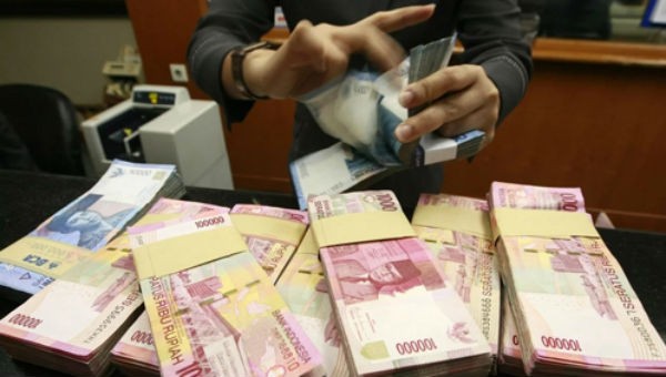 Một nhân viên giao dịch đếm tiền mặt tại ngân hàng ở thủ đô Jakarta, Indonesia