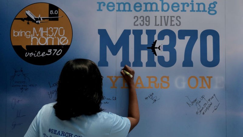 Một thân nhân của hành khách trên chuyến bay MH370 viết lên tấm bảng trong sự kiện tưởng niệm 5 năm máy bay mất tích.